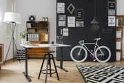 Ergonomisch elektrisch zit-sta bureau met slank zwart frame en licht eiken blad, verstelbaar in hoogte. - Elektrisch Zit-Sta Bureau OFI DYNAMO – NPR 1813 & Ergonomisch - Office Furniture Interior