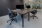 Ergonomische bureaustoel met zwarte mesh rugleuning en verstelbare armleuningen aan bureau. - Bureaustoel OFI FLEX – Ergonomisch NPR 1813 - Office Furniture Interior